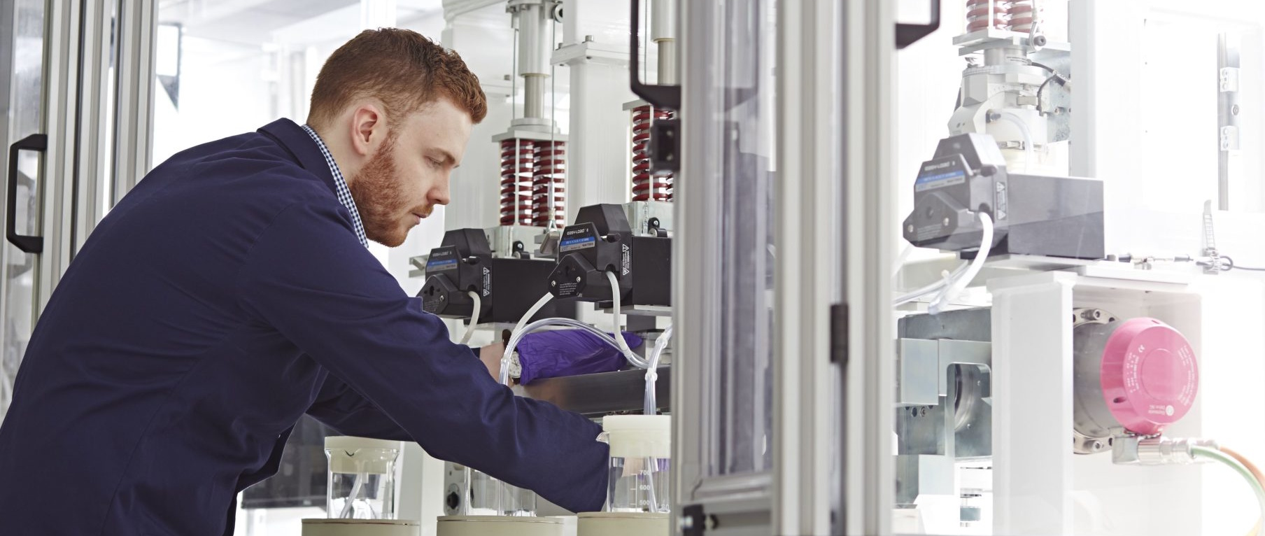 Photo of a scientist operating a hip replacement mechanical joint simulator